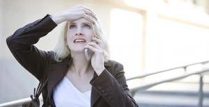 Young woman using mobile phone, hand to head, portrait